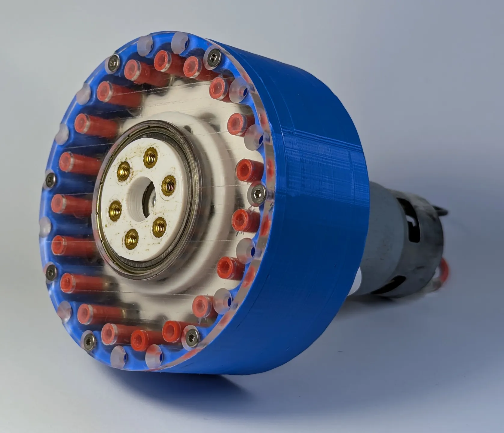3D-printed cycloidal drive gearbox in blue with clear pins and brass inserts, coupled to a DC motor