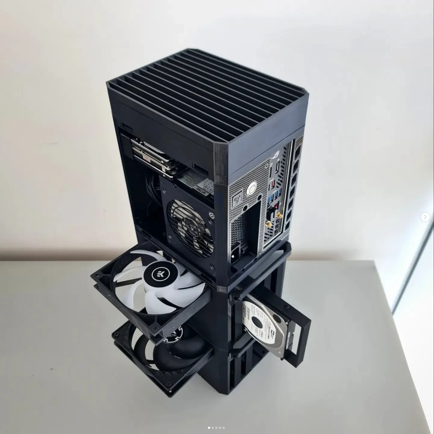3D-printed stackable NAS and mini-ITX PC case shown with fans, a hard drive, and motherboard modules